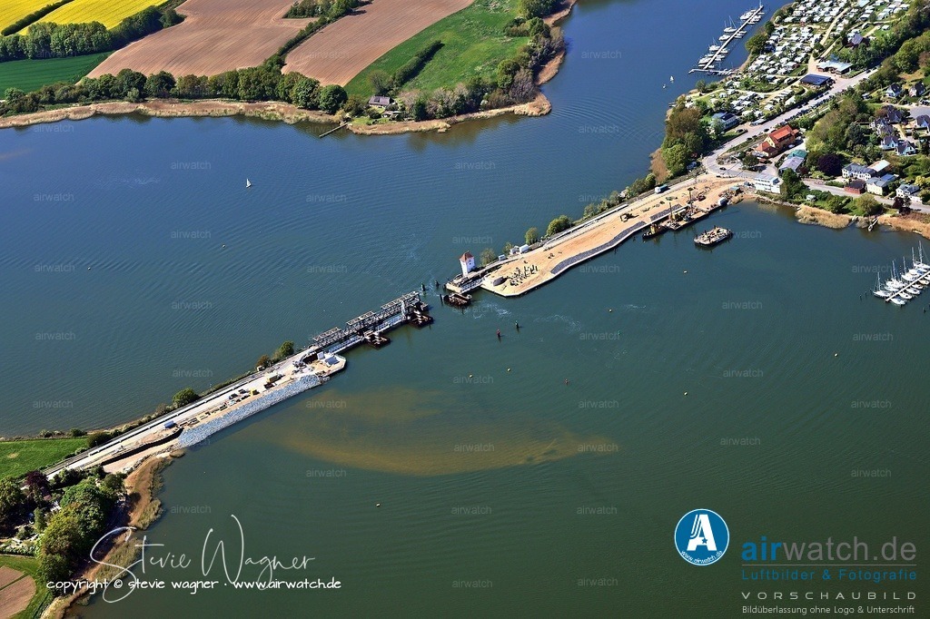 Luftbild Ostseefjord Schlei, Boren-Lindaunis Schleibrücke, Campingplatz Lindaunis, Sportboothafen Lindaunis | Die Schleibrücke Lindaunis, eine historische Rollklappbrücke über die Schlei in Schleswig-Holstein, hat eine lange und komplexe Geschichte. Ihre Vorgängerin war eine Drehbrücke, die von 1881 bis 1926 an derselben Stelle existierte und die Eisenbahnstrecke Kiel–Flensburg über die Schlei verband.