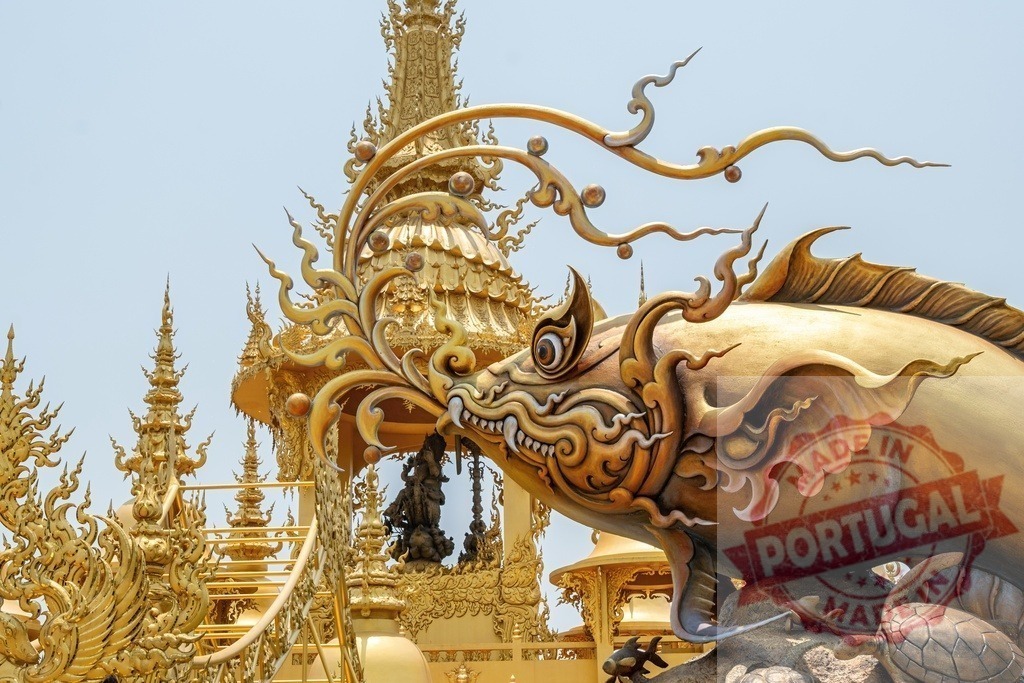 Golden fish statue spitting water in Wat Rong Khun, Thailand, with ornate details | Golden fish statue spitting water with intricate details, surrounded by ornate architecture in Wat Rong Khun, also known as White Temple, in Chiang Rai, Thailand - Realized with Pictrs.com