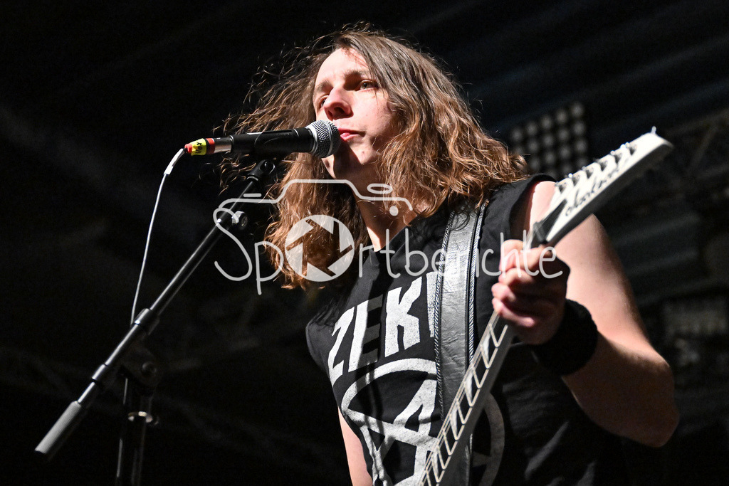 Evil Obsession | Hellripper Frontmann Jamec McBAIN mit Gitarre beim Konzert in Regensburg am Mikrofon / Evil Obsession Part II, Eventhall Airport am 29.12.2024