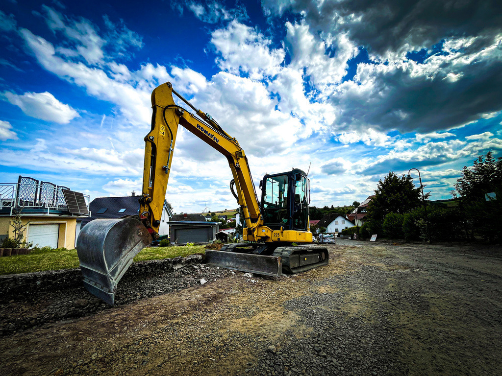 Bagger - Wenings | Auch ein relativ kleiner Komatsu Bagger wirkt im Weitwinkel-Objektiv Massiv. Ein gemütlicher Spaziergang durch Wenings kann schnell zu einem außergewöhnlichen Erlebnis werden. Dafür bedarf es lediglich einer Kamera mit Weitwinkel-Objektiv und ein wenig Abenteuerdrang. Dann werden sogar sonst verpönte Baustellen zu einer Inspiration für neue Blickwinkel. Vielleicht treibt diese Idee den ein oder anderen Hobby-Fotografen mit der nötigen Ausrüstung am Wochenende aus dem Wohnzimmer und in die Dorfmitten. - Realisiert mit Pictrs.com