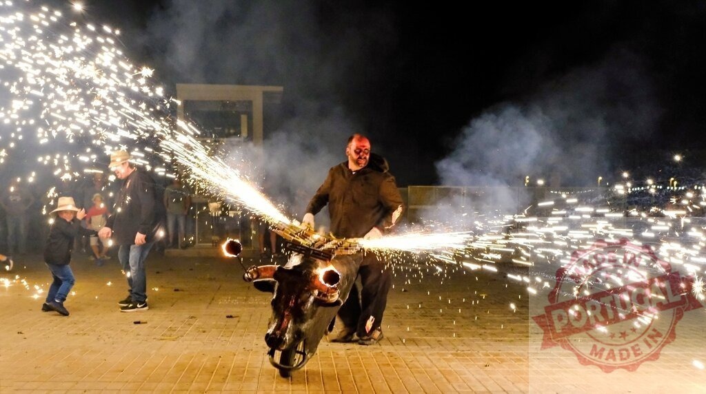 Person holding toro de fuego sparking fireworks at night festival | Person wearing a bull effigy with fireworks, creating sparks on a night street during a festival - Realisiert mit Pictrs.com
