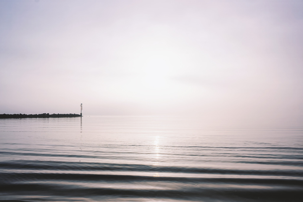 Frühes Licht über der See – Weite und Gelassenheit | Dieses Motiv zeigt die stille Weite des Meeres im sanften Licht des frühen Morgens. Die Wasseroberfläche trägt feine Bewegungen, die das weiche Licht subtil reflektieren. Über dem Horizont liegt ein zarter Dunst, der die Szene in eine ruhige, fast meditative Atmosphäre taucht. Die weichen Wolken und die klare, reduzierte Komposition betonen die natürliche Gelassenheit und die besondere Stimmung des beginnenden Tages. Als Wandbild erhältlich auf Acrylglas und weiteren hochwertigen Materialien.