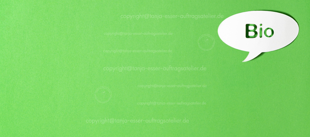 Bio gruen D | Deutscher Text Bio in einer Sprechblase aus Papier ausgestanzt vor grünem Papier Hintergrund.