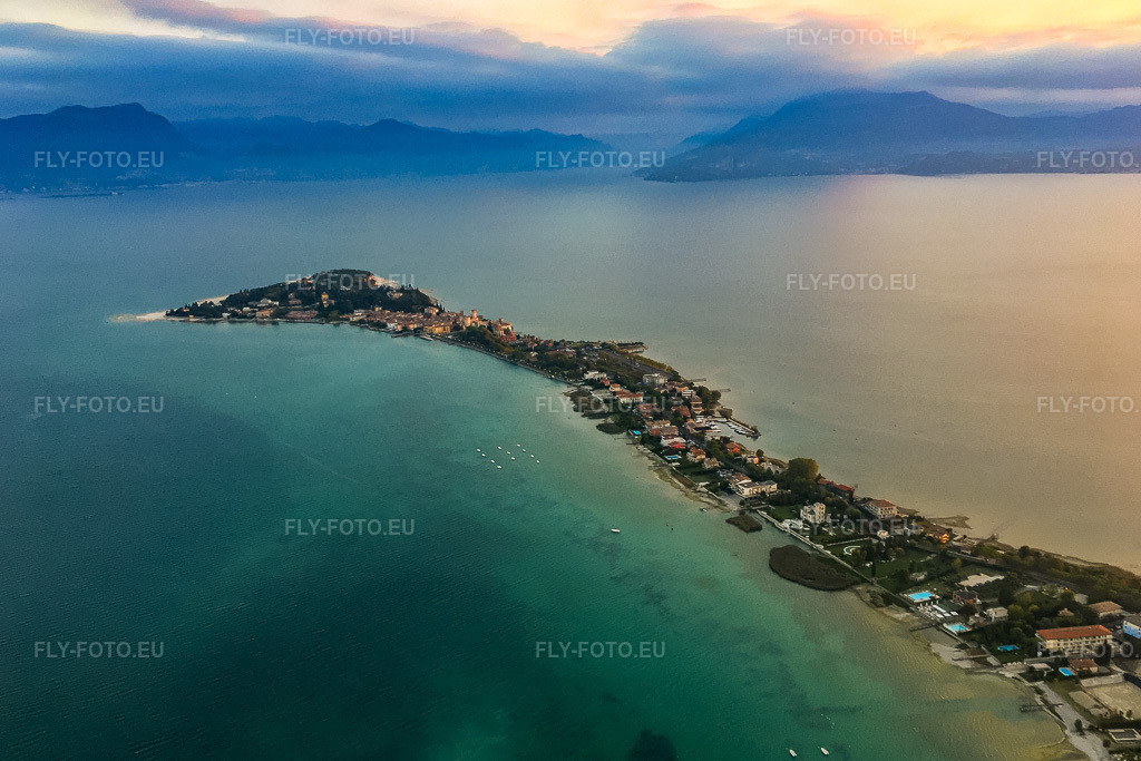 Vue aérienne: Ambiance matinale sur la péninsule Sirmione du lac de Garde à Sirmione dans le département Brescia, Italie. Photo: IMG-134984.jpg prise le 23/09/2022 par Werner Riehm/FLY-FOTO.eu – Résolution de l'original: 3896 x 2597 px