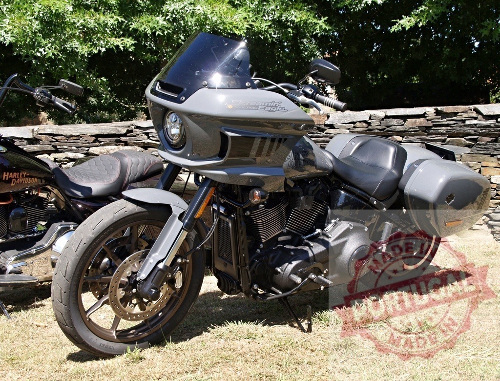 Harley-Davidson Sport Glide motorcycle parked on grass near stone wall | Modern Harley-Davidson Sport Glide motorcycle with fairing and panniers parked near stone wall - Realisiert mit Pictrs.com