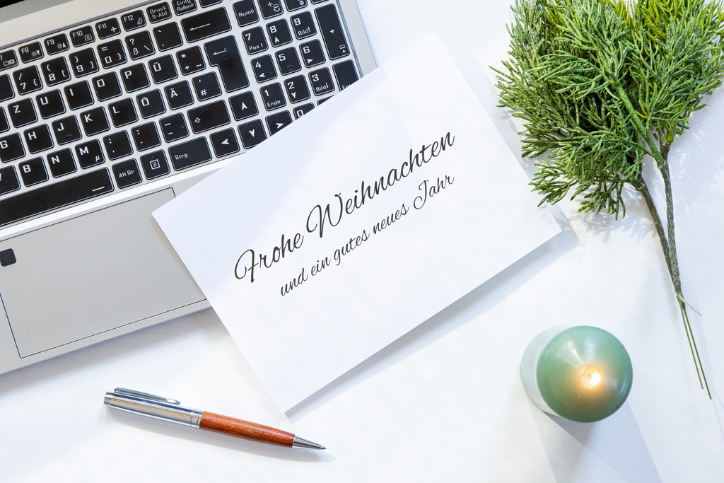 Weihnachtsgrüße und Silvestergrüße für Geschäftskunden mit Laptop, Grußkarte und dezenter Weihnachtsdekoration auf einem hellen Schreibtisch | Weihnachtsgrüße und Silvestergrüße für Geschäftskunden mit Laptop, Grußkarte und dezenter Weihnachtsdekoration auf einem hellen Schreibtisch - Realisiert mit Pictrs.com