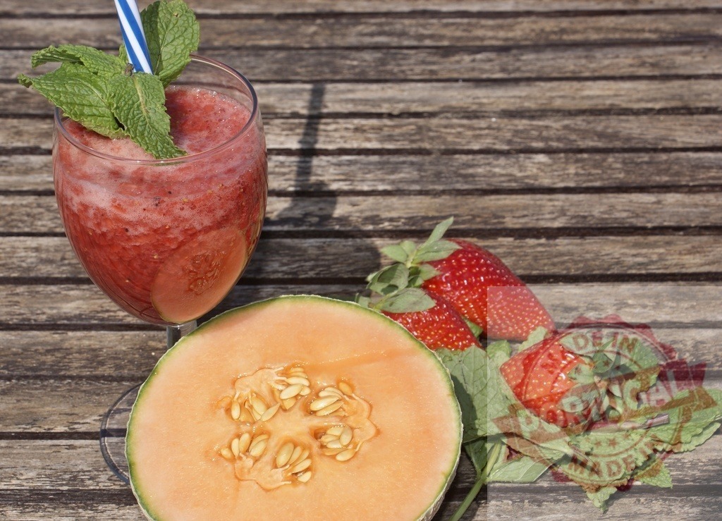 Strawberry cantaloupe smoothie drink refreshing summer | Strawberry cantaloupe smoothie with mint and cantaloupe slices on wooden table - Realisiert mit Pictrs.com