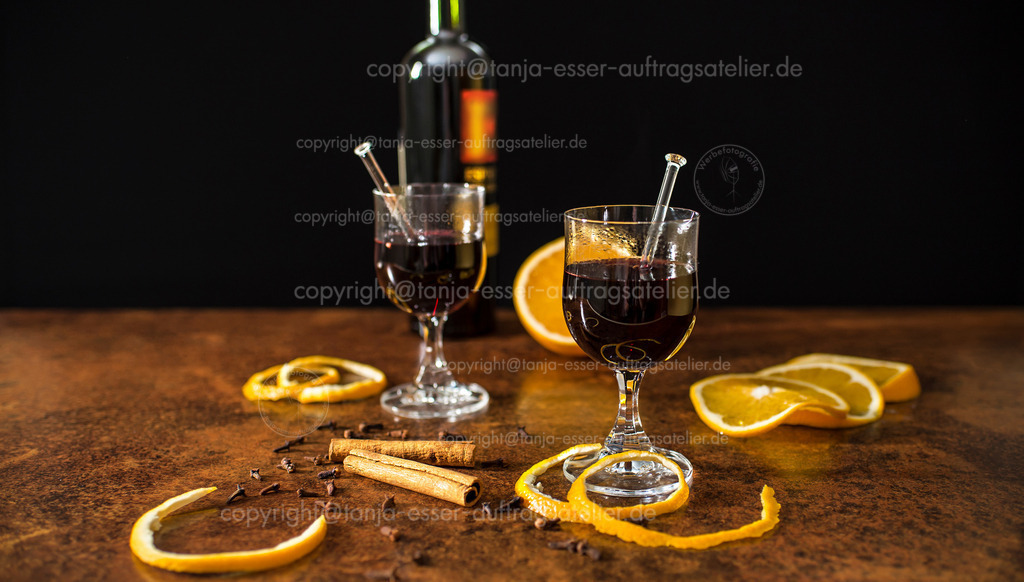 Mulled wine with spices and oranges close up in front of black background | Glühwein mit Gewürzen und Orangen Nahaufnahme vor schwarzem Hintergrund