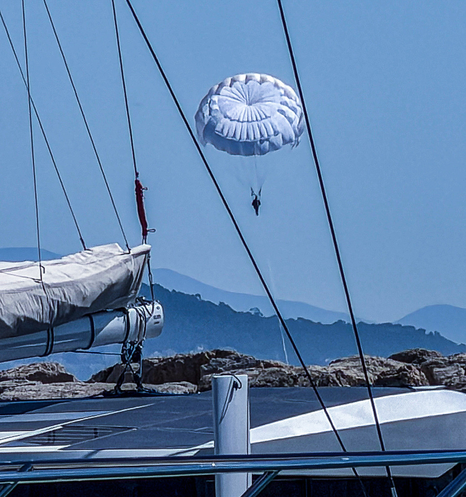 Wandbild Kunstdruck Poster Parasailing über dem Meer – Maritime Fotokunst | Erleben Sie das pure Gefühl von Freiheit, Abenteuer und endlosem Sommer in Ihren eigenen vier Wänden. Dieses exklusive maritime Wandbild fängt den perfekten Moment ein, in dem ein Fallschirm elegant über dem tiefblauen, glitzernden Ozean schwebt, gezogen von einer eleganten Yacht. Ein absoluter Blickfang für alle, die das Meer, luxuriöse Reisen und moderne Sport-Ästhetik lieben. Gedruckt auf Premium-Leinwand, feinstem Alu-Dibond oder kristallklarem Acrylglas garantiert dieses Kunstwerk maximale Farbbrillanz und eine beeindruckende Tiefenwirkung in Wohnzimmer, Büro oder Ferienwohnung. - Realisiert mit Pictrs.com