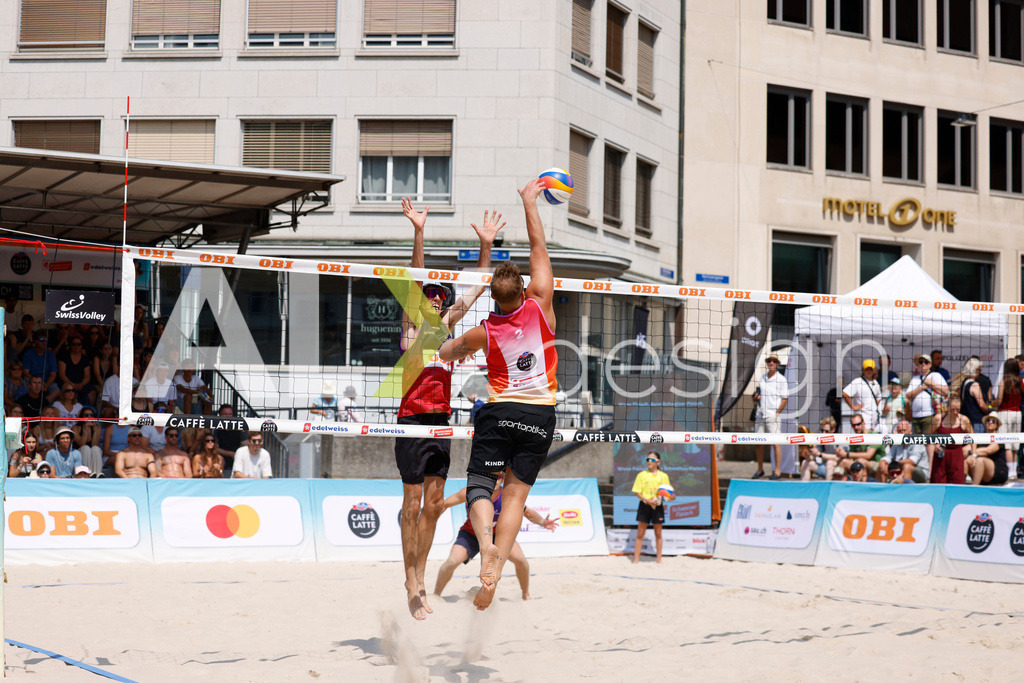 Obi BeachTour 2026 - Basel | BASEL, SWITZERLAND - JULY 19: MORITZ KINDL (AUT) attack / spike against SIMON HAGENBUCH (SUI) block during the Obi BeachTour 2026 match between HAGENBUCH / HAUSSENER (SUI) and LEITNER / KINDL (AUT) at Barfüsserplatz on July 19, 2026 in Basel, Switzerland. - Realisiert mit Pictrs.com
