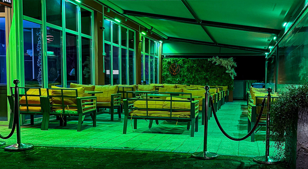 Emerald Night | A neon-lit urban lounge glowing in deep green tones, combining modern geometry, reflections and cinematic nighttime atmosphere into a moody architectural scene. - Realisiert mit Pictrs.com