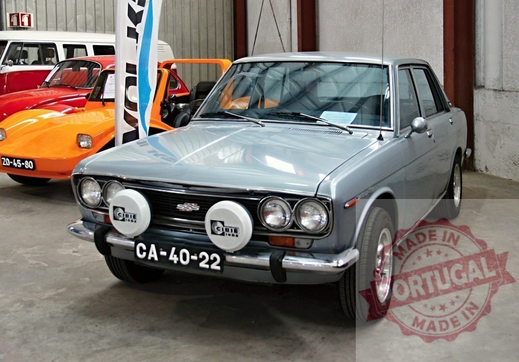 Datsun 510 parked in garage with other vintage cars | Classic Datsun 510 sedan parked in garage next to other vintage vehicles, showcasing automotive history - Realisiert mit Pictrs.com