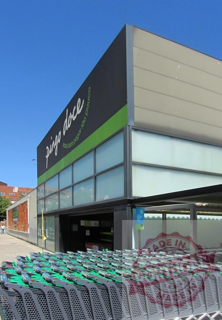 Supermarket Pingo Doce building with many shopping carts | Supermarket building with branding Pingo Doce, shopping carts lined up under a clear sky - Realisiert mit Pictrs.com