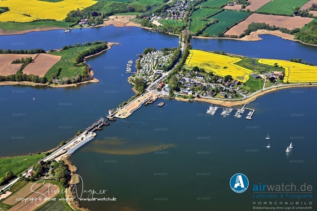 Luftbild Ostseefjord Schlei, Boren-Lindaunis Schleibrücke, Campingplatz Lindaunis, Sportboothafen Lindaunis | Luftbild Ostseefjord Schlei, Boren-Lindaunis Schleibrücke: Die Lindaunisbrücke ist eine Straßen- und Eisenbahnklappbrücke, die den Meeresarm Schlei an einer seiner schmalsten Stellen überquert und die Halbinseln Schwansen und Angeln verbindet. Sie liegt im Gemeindeteil Lindaunis der Gemeinde Boren in Schleswig-Holstein und ist Teil der Bahnstrecke Kiel–Flensburg sowie der Landesstraße L 283