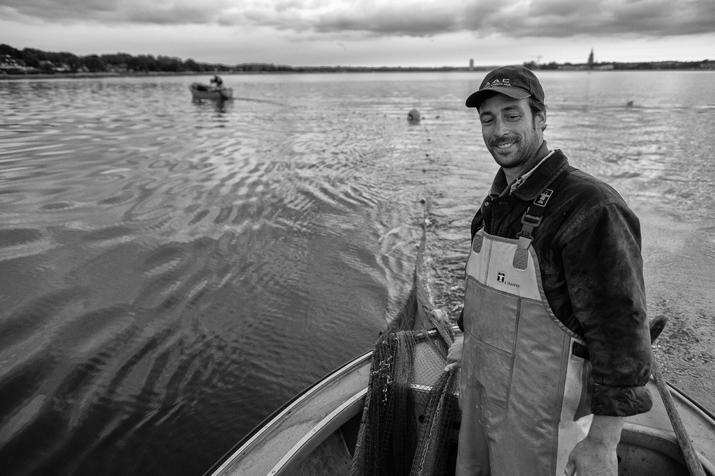 Wadenfischen auf der Schlei © Holger Rüdel | Beim Wadenfischen sind meistens zwei Boote parallel im Einsatz: beim Ausbringen des Netzes in größerem Abstand, bei der Fahrt zum nächsten Fangplatz dicht an dicht wie hier auf der Kleinen Breite der Schlei mit den Fischern Jörn und Nils Ross (rechts) aus Schleswig. - Realisiert mit Pictrs.com
