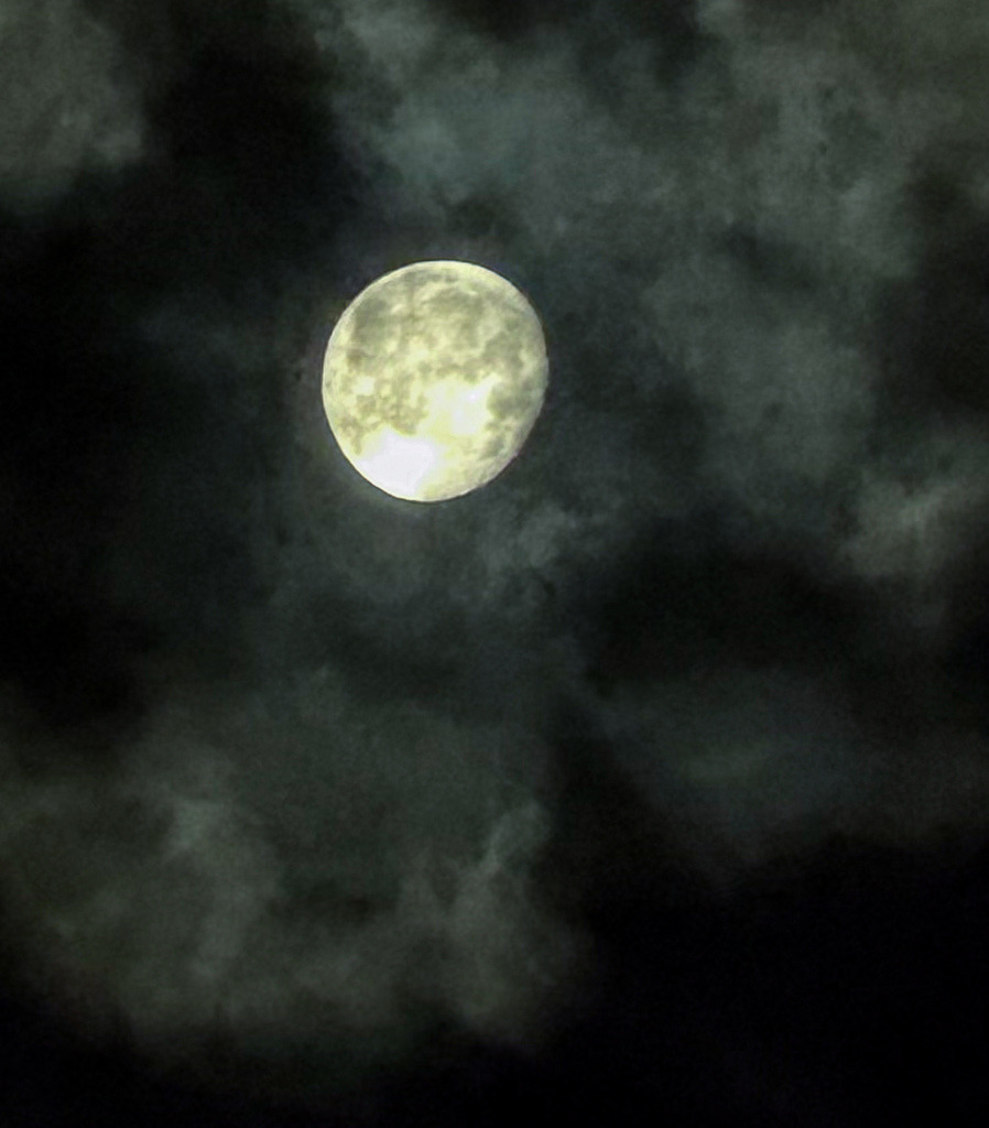 Nachtakzente – Vollmond I | Exklusive Vollmond-Fotografie in Galerie-Qualität. Gestochen scharf blickt der leuchtende Mond durch eine mystische, nebelartige Wolkendecke. Die feinen Kraterstrukturen im Kontrast zu den weichen, dunklen Wolkenformationen machen diesen Fine Art Print zu einem faszinierenden Blickfang. Ein zeitloses Kunstwerk, das besonders in Schlafbereichen oder stilvollen Wohnräumen eine beruhigende Tiefe entfaltet. - Realisiert mit Pictrs.com