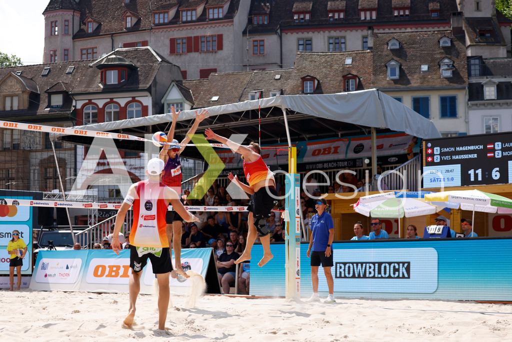 Obi BeachTour 2026 - Basel | BASEL, SWITZERLAND - JULY 19: MORITZ KINDL (AUT) attack / spike against SIMON HAGENBUCH (SUI) block during the Obi BeachTour 2026 match between HAGENBUCH / HAUSSENER (SUI) and LEITNER / KINDL (AUT) at Barfüsserplatz on July 19, 2026 in Basel, Switzerland. - Realisiert mit Pictrs.com
