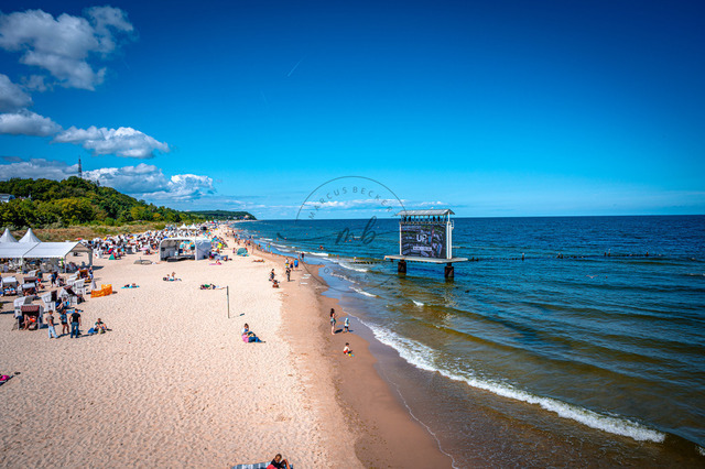 2026-08-08_12-54-49_690 | Belebter Sandstrand mit Menschen im Wasser und Sonnenschein unter blauem Himmel, Heringsdorf, Usedom, Mecklenburg-Vorpommern, Deutschland - Realisiert mit Pictrs.com