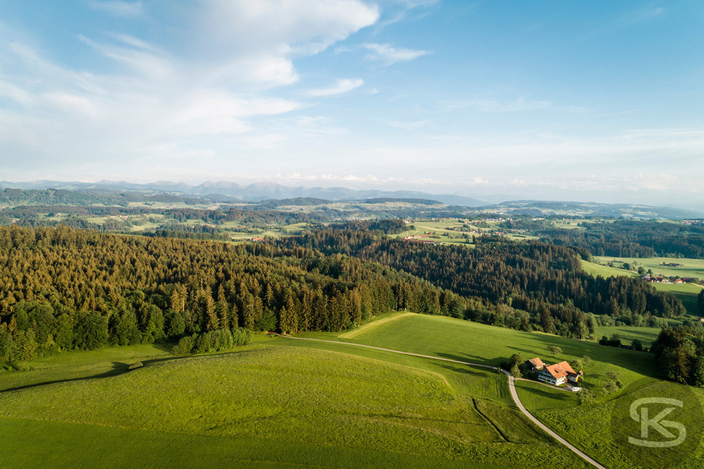 Wunderschöne Allgäu-Landschaft aus der Luft – Hügel, Wälder und Alpenpanorama | Atemberaubende Luftaufnahme des Allgäus mit sanften Hügeln, dichten Wäldern und Alpenblick. Idylle, Weite und Natur pur – perfekt für Tourismus &amp; Inspiration. - Realisiert mit Pictrs.com