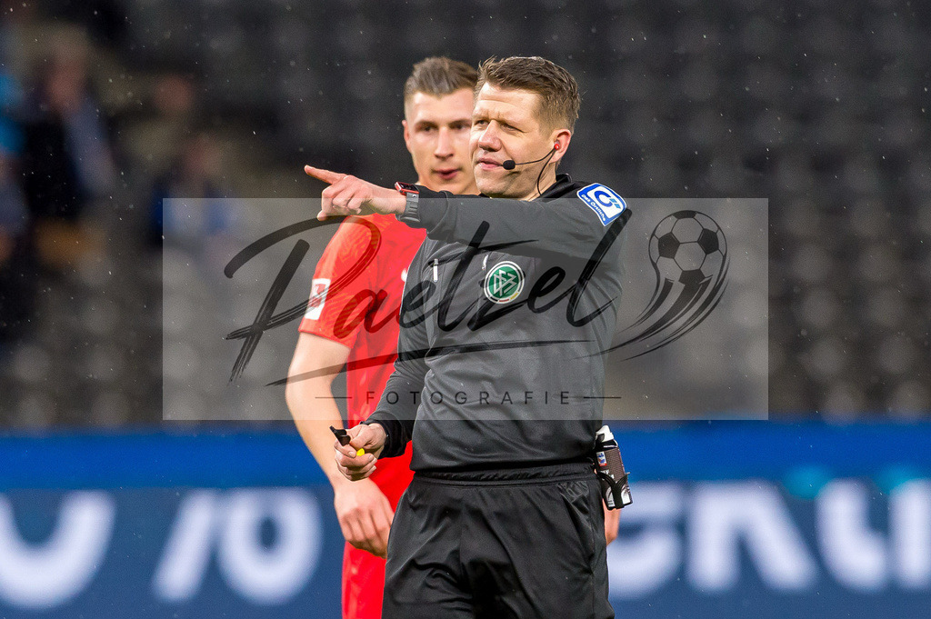 BSCRBL20220220_180 | Fussball, Herren: Schiedsrichter Patrick Ittrich gestikuliert, Gestik bei dem Spiel der 1. Bundesliga zwischen Hertha BSC und RB Leipzig im Olypiastadion am 20.02.2022 in Berlin, Deutschland.DFB / DFL REGULATIONS PROHIBIT ANY USE OF PHOTOGRAPHS AS IMAGE SEQUENCES AND/OR QUASI-VIDEO. - Realisiert mit Pictrs.com