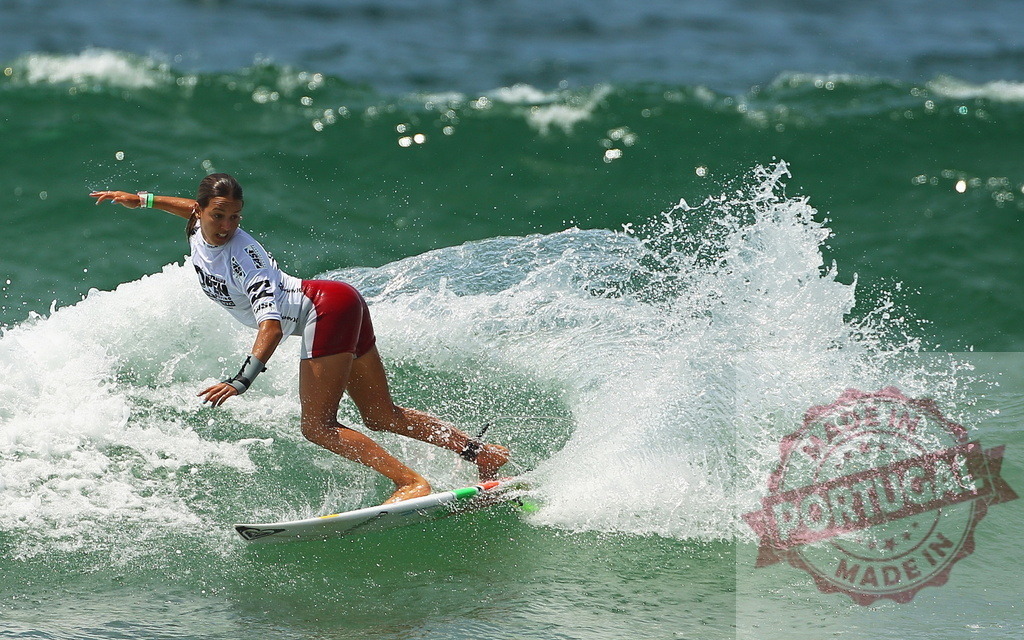 Professional surfer riding a wave during a competition | Female athlete surfing a wave during a competition, performing maneuvers with skill and precision - Realized with Pictrs.com