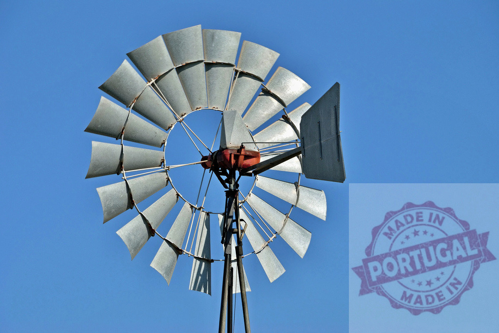 Old wind pump blades rotating against blue sky. Centro - Portugal | Wind pump spinning, providing water for rural farms and representing renewable energy - Realized with Pictrs.com