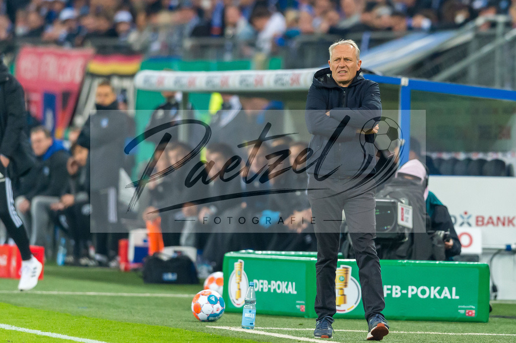 HSVSCF20220419_080 | Fussball, Herren: Trainer Christian Streich (SC Freiburg) schaut beim DFB-Pokal-Halbfinalspiel zwischen Hamburger SV und SC Freiburg im Volksparkstadion am 19.04.2022 in Hamburg, Deutschland.DFB / DFL REGULATIONS PROHIBIT ANY USE OF PHOTOGRAPHS AS IMAGE SEQUENCES AND/OR QUASI-VIDEO. - Realisiert mit Pictrs.com
