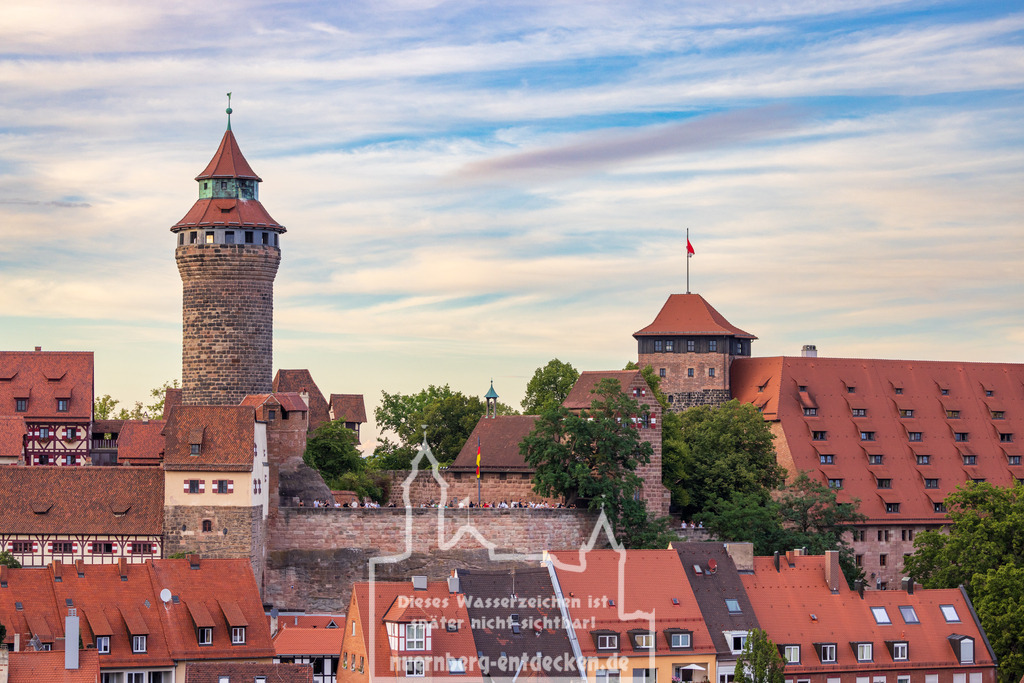 Nürnberger Stadtbild am Abend | Das Foto zeigt die Kaiserburg in Nürnberg, Bayern, Deutschland, kurz vor dem Sonnenuntergang während des gleichzeitigen Mondaufgangs. Die Aufnahme fängt das warme, goldene Licht ein, das die Ziegeldächer der Altstadt und die mittelalterlichen Türme der Burg in ein sanftes, leuchtendes Licht taucht. - Realisiert mit Pictrs.com