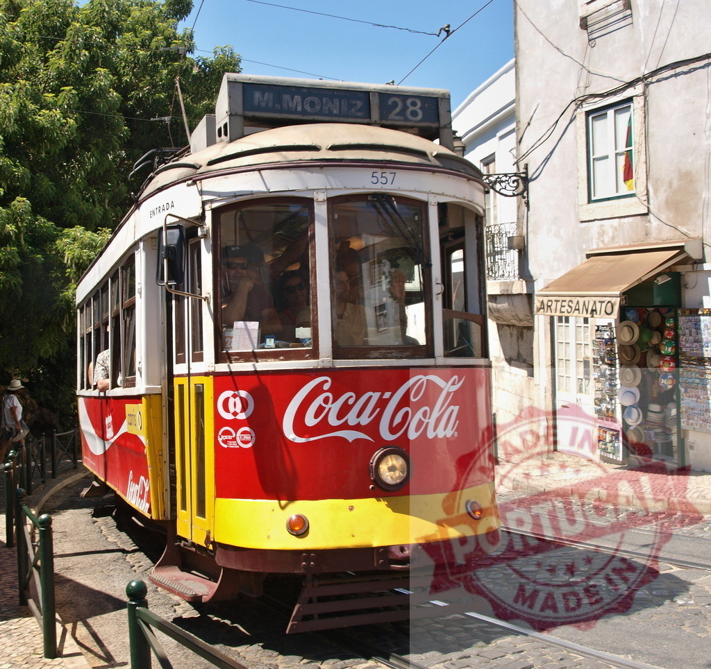 Vintage yellow and red tram driving on lisbon street | Vintage yellow and red Coca-Cola tram driving on cobblestone street in Lisbon, Portugal - Realisiert mit Pictrs.com