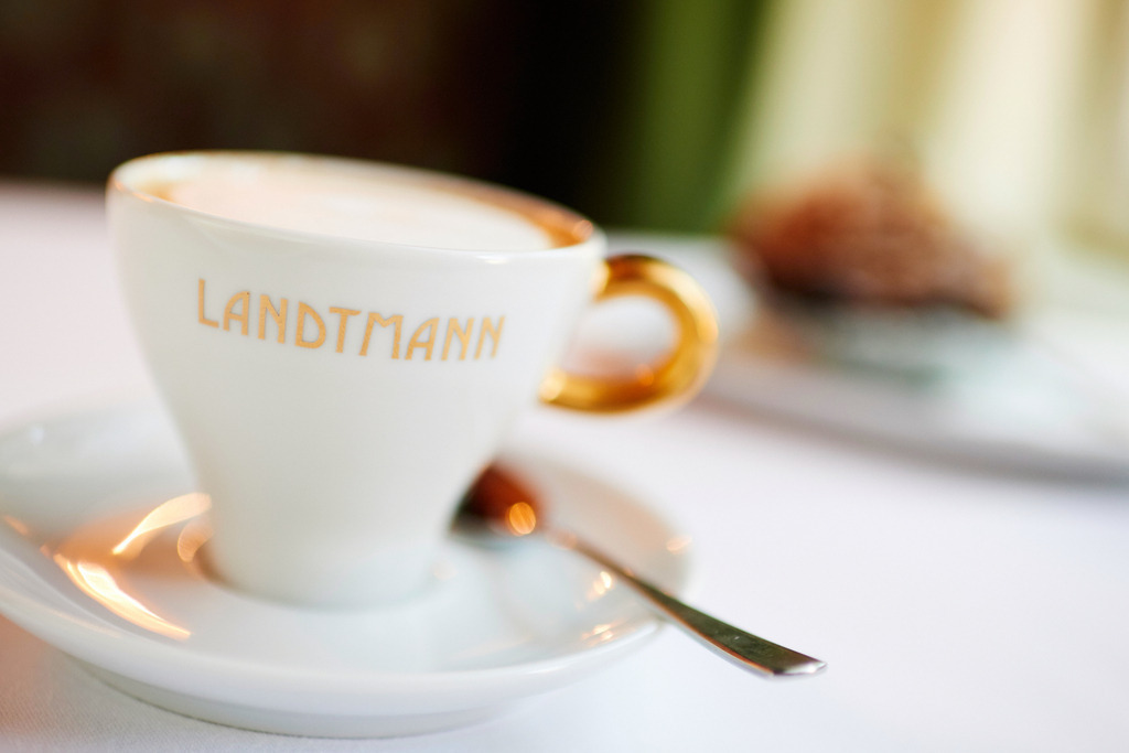 Cafe Landtmann | Wien, Austria - October 11, 2018: Cafe Landtmann - eine Tasse Melange mit goldenem Landtmann Schriftzug. - Realisiert mit Pictrs.com