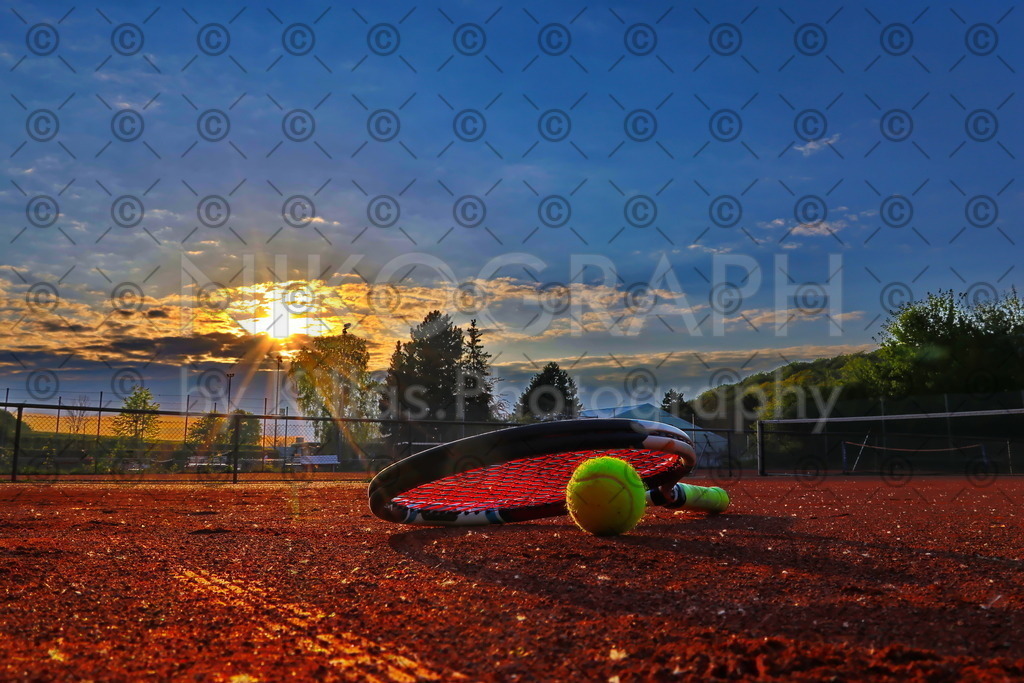 Sonnenuntergang am Tennisplatz | Die Sonnenstrahlen der Abendsonne lassen den Tennisplatz golden leuchten. Die Bespannung des Tennisschlägers glüht förmlich im Licht des Sonne.