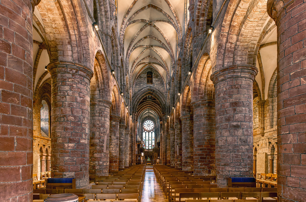 Innenraum der St. Magnus Cathedral in Kirkwall, Schottland | Dies ist der Innenraum der St. Magnus Cathedral in Kirkwall, Schottland, einer mittelalterlichen Kathedrale aus dem 12. Jahrhundert.Die Architektur zeichnet sich durch massive, normannische Säulen aus rotem und gelbem Sandstein aus.Sie gilt als die älteste Kathedrale Schottlands und die nördlichste im Vereinigten Königreich. - Realisiert mit Pictrs.com