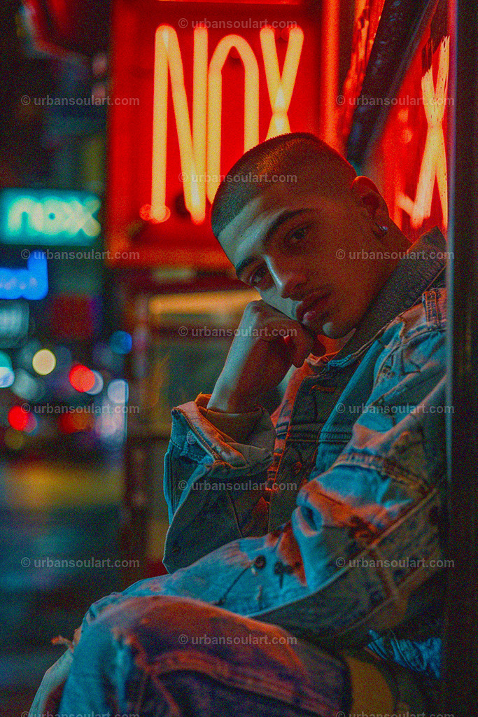 Young Man Next To Neon Sign | A striking urban portrait of a young man posed beside a glowing neon sign, this image brings a sense of modern style and city energy. Perfect for contemporary spaces, this artwork adds a cool, vibrant vibe. - Realisiert mit Pictrs.com