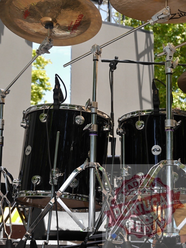 Drum kit set up on outdoor stage for concert | Drum kit with cymbals and drums ready for a live music performance - Realized with Pictrs.com