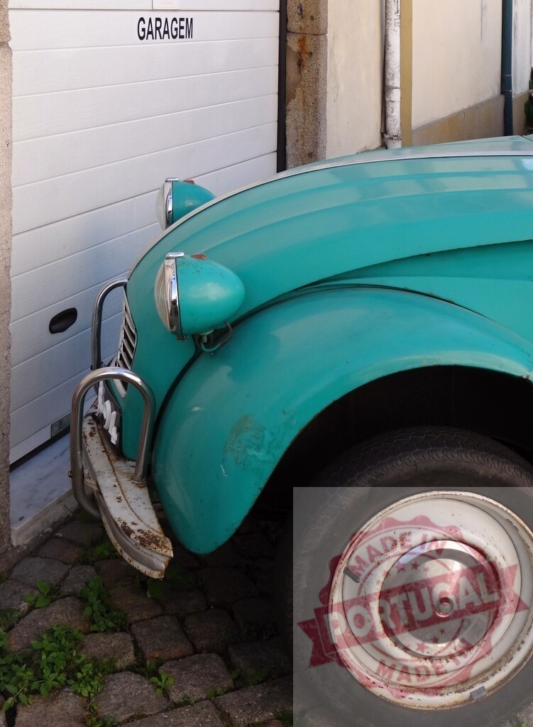 Citroën 2CV car parked by a garage door | Turquoise vintage Citroën 2CV vehicle parked outdoors on cobblestone street near a garage door - Realisiert mit Pictrs.com