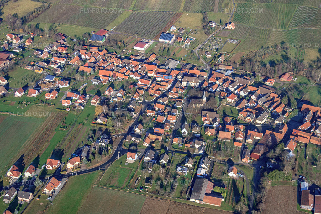 Aerial view: Village center from the south with Protestant Temple Saint Laurent in Steinseltz in the state Bas-Rhin, France. – Photo: IMG_48441.jpg taken on 12/11/2011 by Werner Riehm/FLY-FOTO.com – Resolution of the original: 4752 x 3168 px