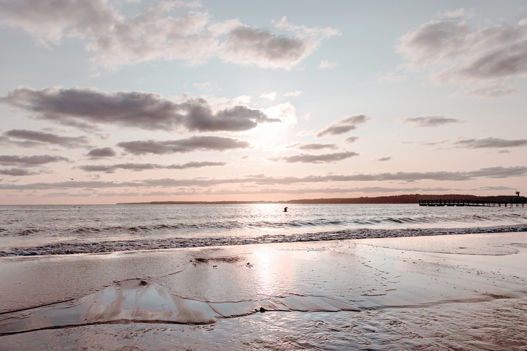 Wandbild: Sonnenaufgang am Meer | Dieses Wandbild zeigt die aufgehende Sonne am Meer. Die Sonne spiegelt sich auf der Wasseroberfläche. Am hellblauen und orangeroten Himmel befinden sich graue Wolken, die teilweise vom Morgenrot angeleuchtet werden. Holen Sie sich diese schöne maritime Morgenstimmung auf Leinwand, Alu-Dibond oder als Glasbild. Ideal fürs Wohnzimmer, Schlafzimmer, Küche, das Büro oder die Ferienwohnung. Die Wandbilder werden individuell für Sie in vielen Abmessungen produziert. Daher passen die Ostseekult Wandbilder immer perfekt an Ihre Wände. - Realisiert mit Pictrs.com