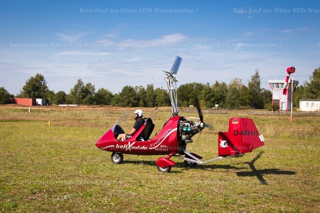 Gyrokopter_7103 | Der Start beginnt auf der Graspiste.Schon beim Rollen wird deutlich, wie kompakt ein Tragschrauber – auch Gyrokopter genannt – aufgebaut ist. Der Motor sitzt offen hinter den Sitzen und treibt einen Propeller an, der für den Vortrieb sorgt. Der große Rotor über dem Cockpit wird dagegen nicht vom Motor angetrieben. Er beginnt sich durch den Fahrtwind zu drehen und erzeugt so den nötigen Auftrieb. Vor dem Start wird der Rotor zunächst auf Drehzahl gebracht – erst dann hebt der Tragschrauber nach wenigen Metern sicher ab. - Realisiert mit Pictrs.com