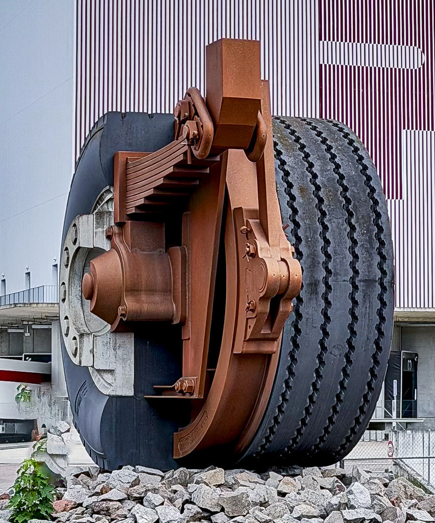 Wandbild Heavy Industrial - LKW-Reifen und mechanische Texturen | Dieses ausdrucksstarke Fine-Art-Wandbild fasziniert durch seine rohe Industrie-Ästhetik und die kraftvolle Materialität schwerer Mechanik. Die detailreiche Nahaufnahme eines wuchtigen LKW-Reifens mit Fokus auf das markante Profil, die Bremstrommel und die Achsenmechanik erzeugt eine beeindruckende visuelle Tiefe. Fotograf Robert Steinke inszeniert diese technische Komposition mit einem scharfen Blick für haptische Oberflächen, raue Kontraste und urbanes Heavy-Duty-Design. Ein absolut charakterstarkes Kunst-Statement für moderne Lofts, maskuline Wohnräume, Garagen-Lounges oder kreative Büros, die eine ehrliche und kraftvolle Atmosphäre versprühen sollen. Perfekt geeignet als großformatiger Premium-Kunstdruck auf edlem Alu-Dibond, Leinwand oder unter brillantem Acrylglas für maximale Tiefenwirkung. - Realisiert mit Pictrs.com