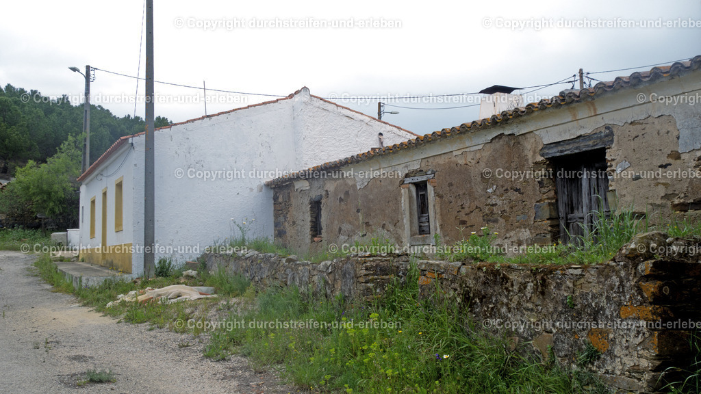 Hof im Tal unterhalb des Megalithgrabs Anta da Masmorra, Mealha, Algarve | In der Nähe des traditionellen Dorfes Mealha,Gemeinde Tavira, im Hinterland der Algarve befinden sich bedeutende prähistorische Fundstätten, die vor allem über Wanderwege erschlossen sind. Das bekannteste Monument in dieser Gegend ist die Anta da Masmorra.Dieses Megalithgrab, Dolmen, ist eines der am besten erhaltenen Beispiele seiner Art in der östlichen Algarve-Region, genauer Serra do Caldeirão. Es handelt sich um eine megalithische Grabkammer (Anta), bestehend aus mehreren aufrecht stehenden Steinen und einem Deckstein. Sie liegt auf einem Hügel etwa zwei Kilometer von Mealha entfernt und bietet einen weiten Blick über die Hügellandschaft. Die Anta ist Teil des Rundwanderwegs PR8 TVR, Mascarra-Trail, der in Mealha beginnt. Die Strecke ist etwa 5,4 km lang und als leicht eingestuft. - Realisiert mit Pictrs.com