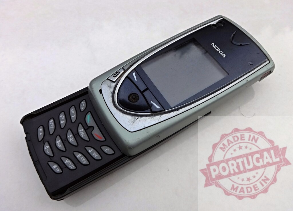 Old Nokia mobile phone showing signs of wear and tear lying on a white surface | Old Nokia mobile phone with visible scratches and wear isolated on a white background - Realisiert mit Pictrs.com
