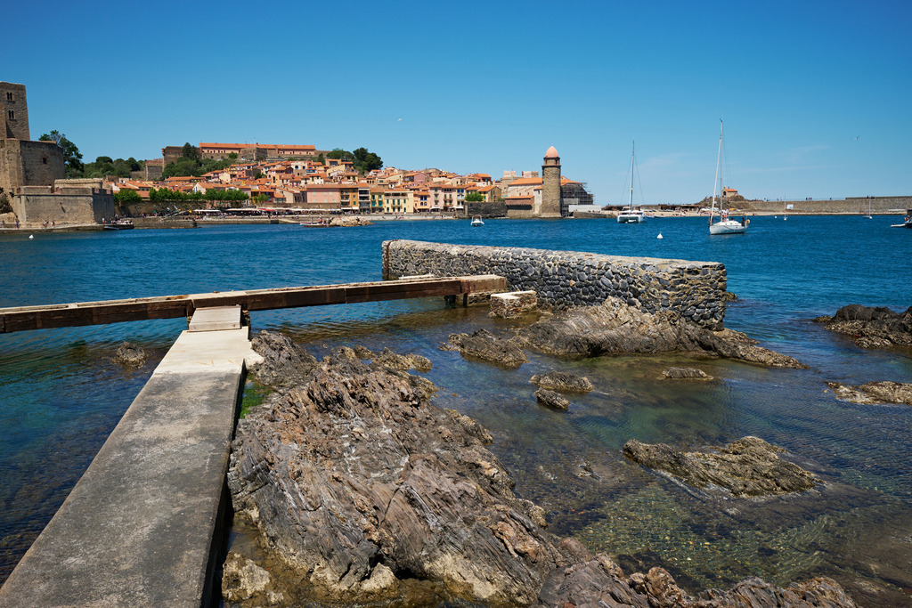 Blick über die Küste auf den Strand von Collioure | Collioure, Frankreich - May 11, 2024: Blick über die Küste auf den Strand von Collioure mit Leuchtturm. - Realisiert mit Pictrs.com