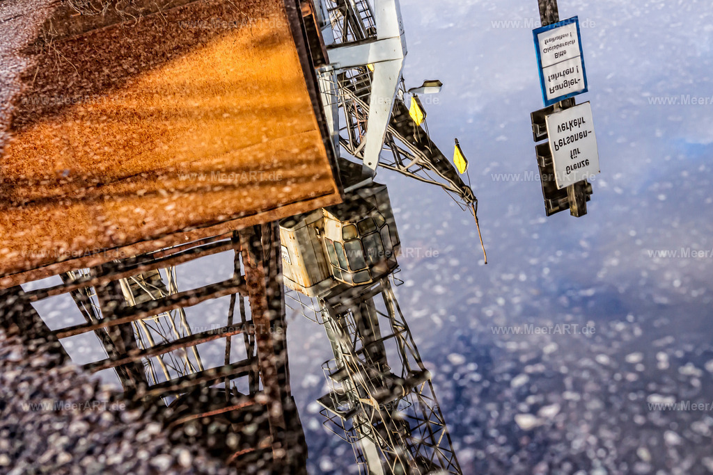 Hamburg - Museumshafen  | Ladekräne an einer Kaimauer im Hamburger Museumshafen spiegeln sich in einer Pfütze |Loading cranes on a quay wall in the port of Hamburg Museum reflected in a puddle| - Realisiert mit Pictrs.com