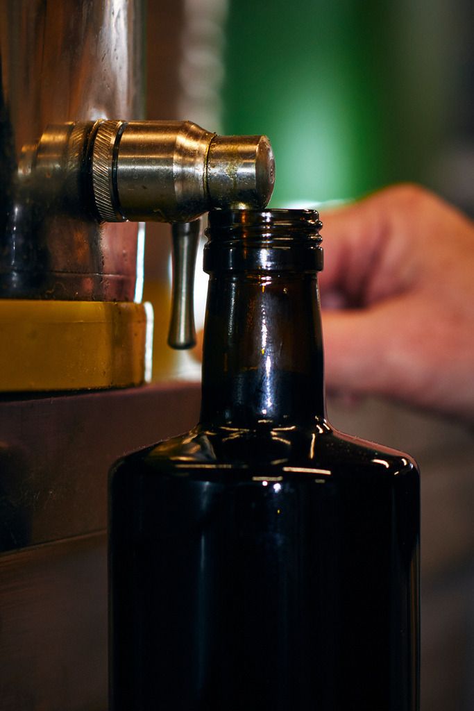 Die Ölmühle | Markt Allhau, Austria - February 09, 2018: Die Oelmuehle; Geschäftsführerin Helga Gradwohl füllt eine Flasche mit Kernöl auf. - Realisiert mit Pictrs.com