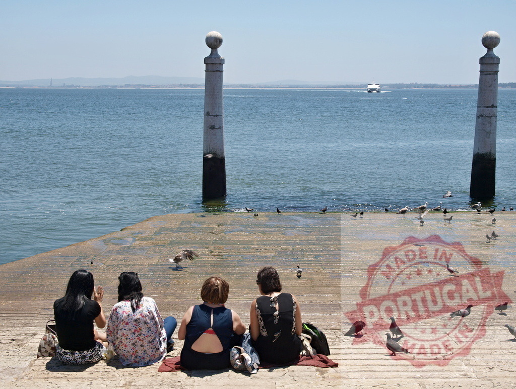 Women relaxing by the Tagus River at Cais das Colunas. Lisbon - Portugal | Women sitting at the historic pier, enjoying the view of the river and a passing boat - Realisiert mit Pictrs.com