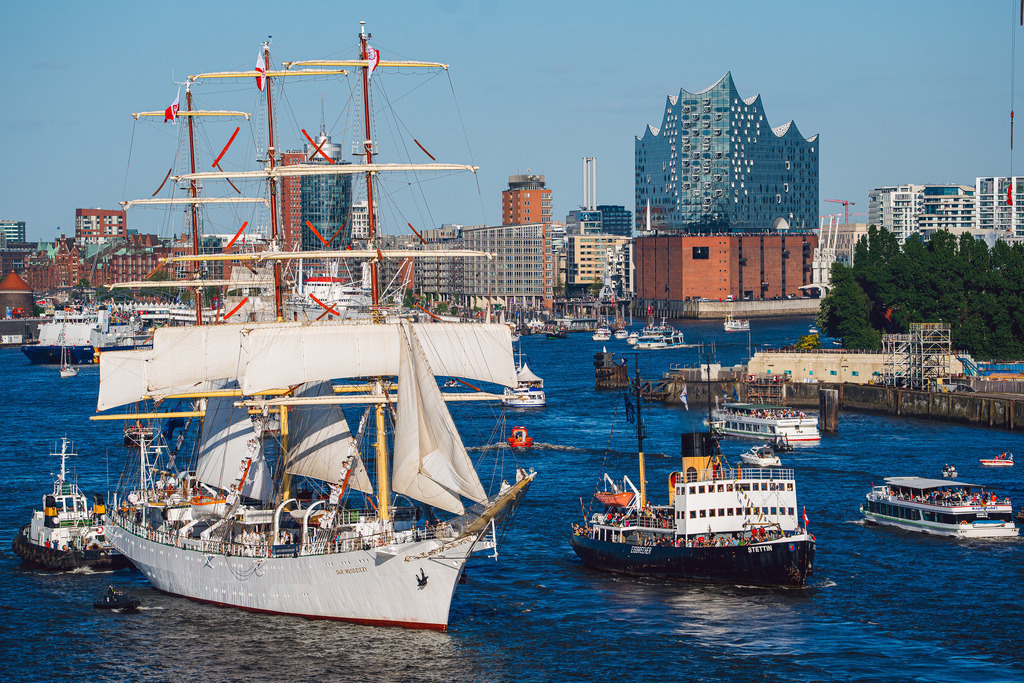 Große Parade: Dar Młodzieży & Stettin | Die Aufnahme zeigt das polnische Segelschulschiff Dar Młodzieży und den historischen Dampfeisbrecher Stettin beim Passieren der Elbphilharmonie. Ein Motiv, das den direkten Kontrast zwischen traditioneller Seefahrt und moderner Architektur im Hamburger Hafen dokumentiert. Aufgenommen während der großen Auslaufparade. - Realisiert mit Pictrs.com