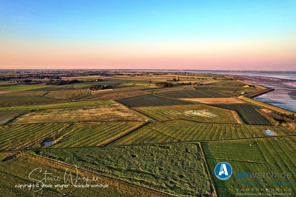 Luftbild Nordstrand, LangerDeich, Dreisprung, Püttenweg, Trendermarsch, Husumer Bucht | Luftbild Nordstrand, LangerDeich, Dreisprung, Püttenweg, Trendermarsch, Husumer Bucht - Der Trendermarschkoog befindet sich im Westen der Insel Nordstrand und grenzt an das Wattenmeer. Er ist nach der ehemaligen runden Insel Trendermarsch benannt, die nahe Alt-Nordstrand lag und bereits im 16. Jahrhundert angeeicht wurde. Die Eindeichung des Trendermarschkoogs erfolgte 1663 nach der schweren Sturmflut von 1634, die den westlichen Teil des Polders zerstörte und in eine Tidefläche verwandelte.