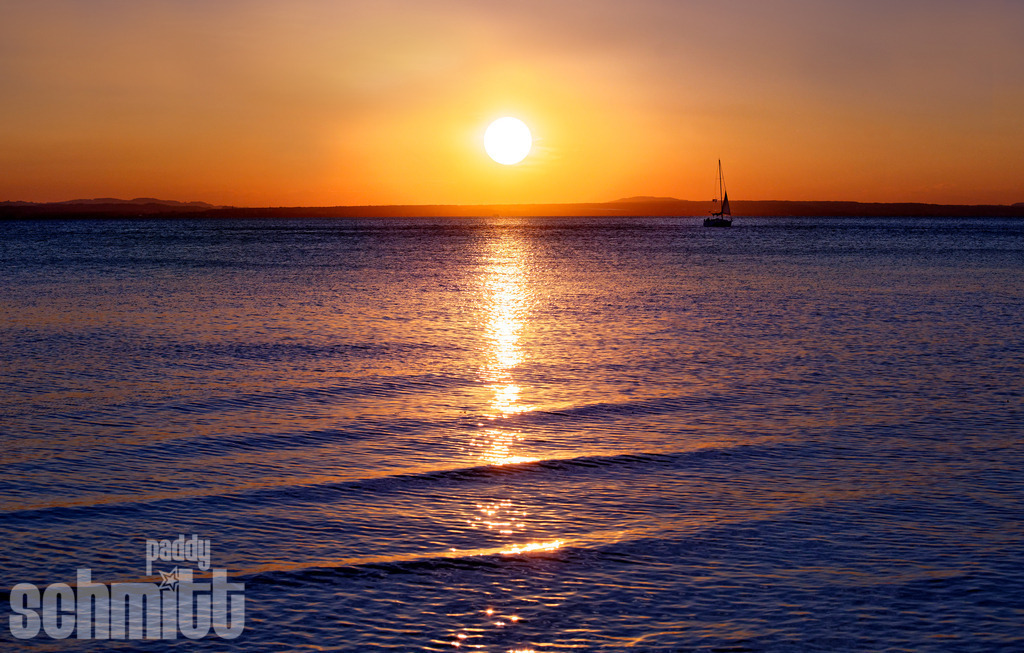 Sonnenuntergang bei Langenargen am Bodensee | Bei Langenargen taucht die untergehende Sonne den Bodensee in warme, goldene Farbtöne. Das ruhige Wasser und das sanfte Abendlicht schaffen eine idyllische Stimmung und fangen die besondere Atmosphäre eines Sommerabends am See ein. - Realisiert mit Pictrs.com