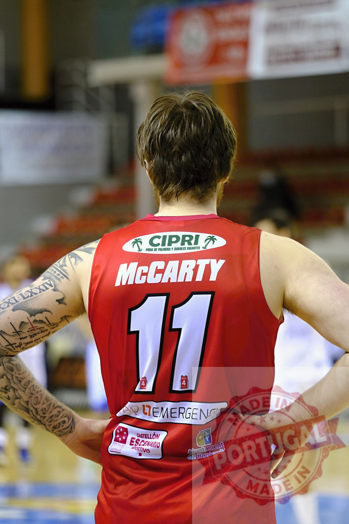 Basketball player McCarty wearing number 11 red jersey | Basketball player standing on a court with hands on hips, looking from behind - Realized with Pictrs.com