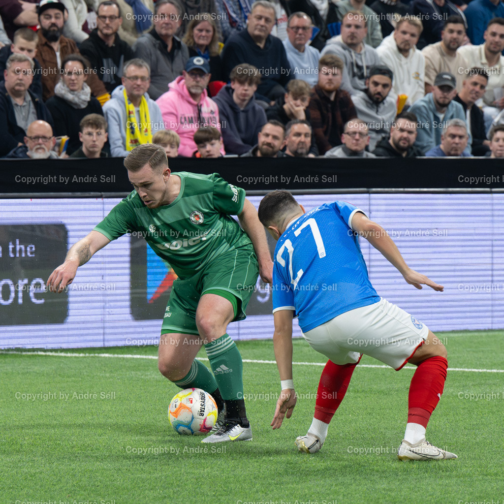 SHFV Lotto Masters 2024 | 20240113_7444, 13.01.2024, SHFV Lotto Masters 2024, Gruppe B, Holstein Kiel (blau) vs. PSV Neumünster (grün), Stanislav Fehler (Holstein #27) / Marc-Oliver Timm (PSV #5) - Realisiert mit Pictrs.com